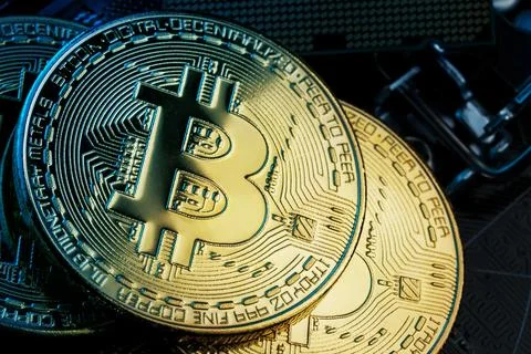 Golden Bitcoin Cryptocurrency on computer circuit board CPU. Macro shot. Stock Photos