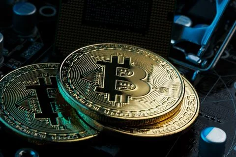 Golden Bitcoin Cryptocurrency on computer circuit board CPU. Macro shot. Stock Photos