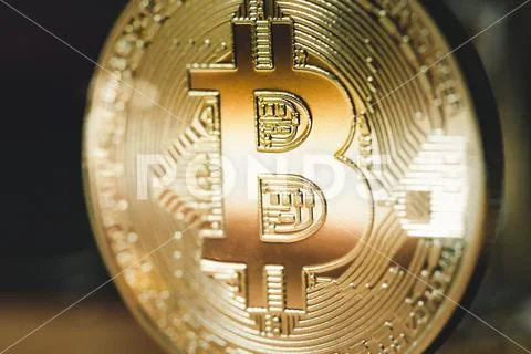Golden Bitcoin on a dark background. Close up Stock Photos