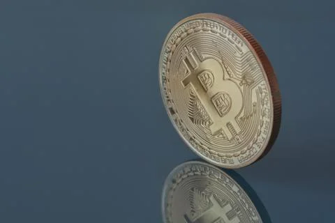 Golden bitcoin on dark background with reflection Stock Photos