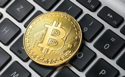 Golden Bitcoin on notebook Stock Photos
