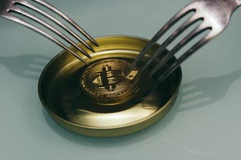 Golden bitcoin with silver fork Stock Photos