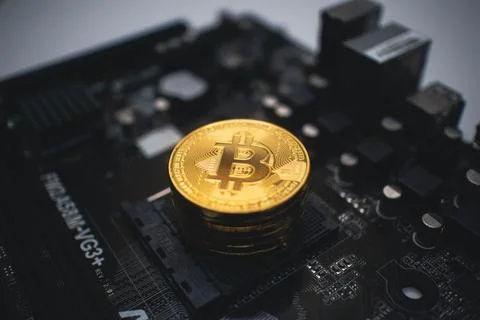 Golden Bitcoin Stack on a Dark Circuit Board. Foto stock