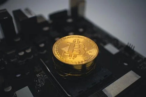 Golden Bitcoin Stack on a Dark Computer Circuit Board. 스톡 사진