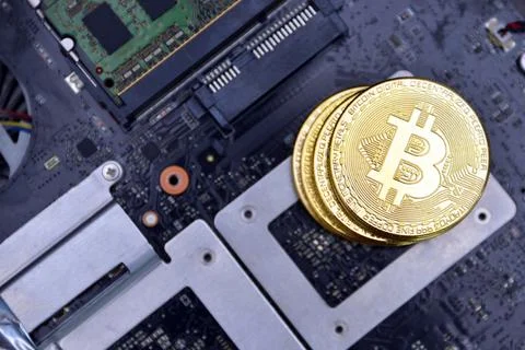 Golden bitcoins on a computer electronic circuit board. bitcoin mining concep Stock Photos