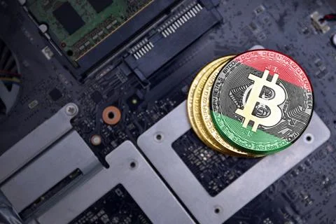 Golden bitcoins with flag of libya on a computer electronic circuit board. .. Stock Photos