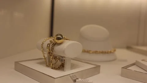 Golden bracelet with bold sphere design displayed in luxury jewelry store under  Stock Footage 315414542