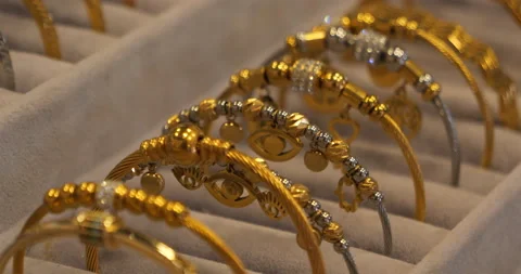 Golden bracelets close-up. Twisted, openwork bracelets made of handmade gold are Stock Footage 222578462