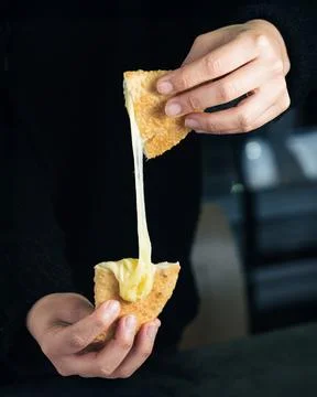 Golden bread pulls apart, stretching melted cheese 库存照片