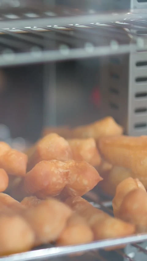 Golden Brown Deep Fried Dough Sticks in Glass Display Case Vídeos de archivo 340135161
