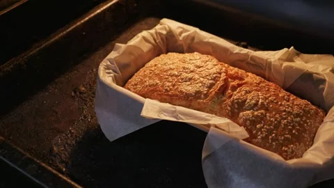 Golden Brown Sesame Bread Baking Inside Dark Oven with Warm Light Stock Footage 334114073