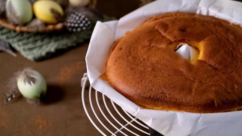 Golden Brown Sponge Cake on Cooling Rack with Easter Decor Stock Footage 332228943
