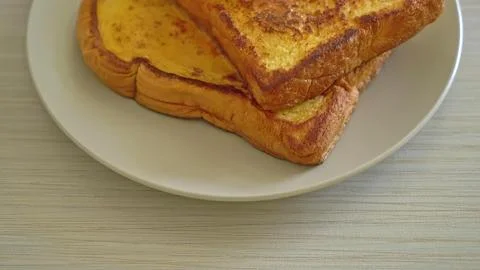 Golden brown toasted bread slice on a white plate Stock Photos