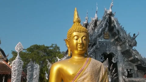 Golden Buddha statue in front of ornate Silver Temple with intricate dragon Stock Footage 315856438