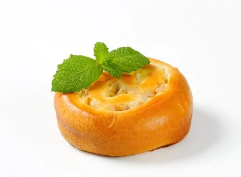 Golden bun with mint leaf garnish Stock Photos