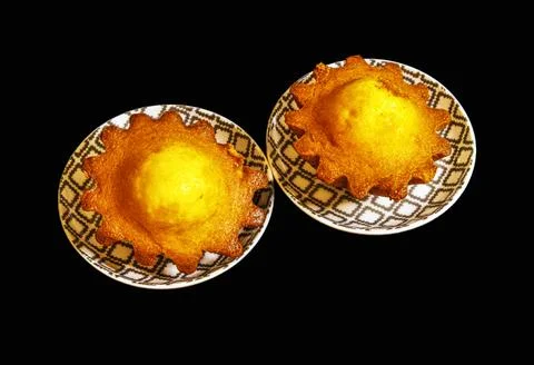 Golden cake centers sit on patterned plates Stock Photos