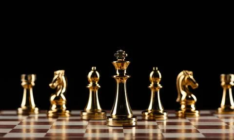 Golden chess figures standing on chessboard Stock Photos