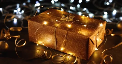 Golden christmas gift wrapped in string lights on flashing background Stock Footage 166227949