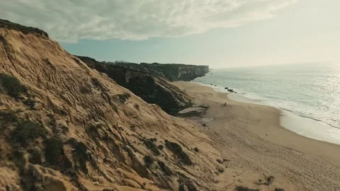 Golden cliffs overlook calm, sunlit beach Stock Footage 340226209