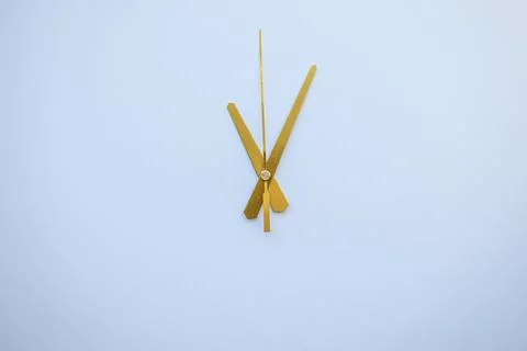 Golden Clock Hands over Clean White Surface for Minimalist Design. Stock Photos