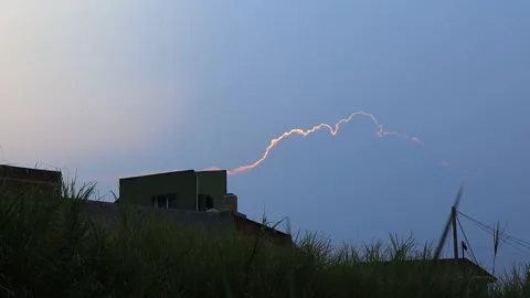 Golden cloud edge glowing at dusk over silhouetted rooftops, Indonesia Stock Footage 342095598