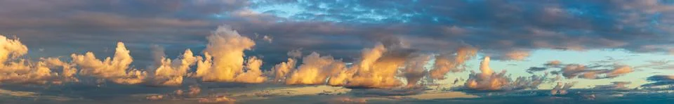 Golden clouds after sunset on a dark blue sky Stock Photos