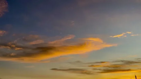 Golden Clouds Drifting Across Blue Sky at Sunset Stock Footage 325527643