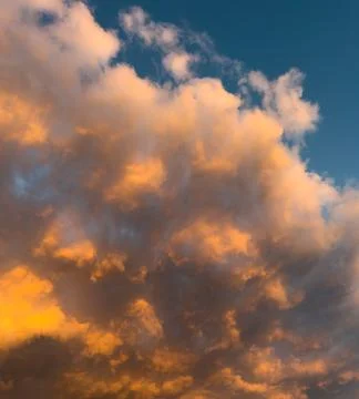 Golden clouds glow against deep blue sky Stock Photos