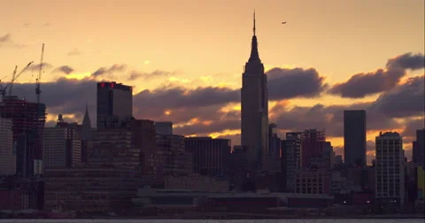 Golden clouds passing by the Empire State Building in the Manhattan skyline Video stock 51295765