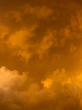 Golden clouds swirl in dramatic, warm-toned sky Stock-Fotos