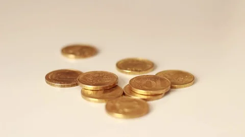 Golden coins dropping on a table Stock Footage 73506926