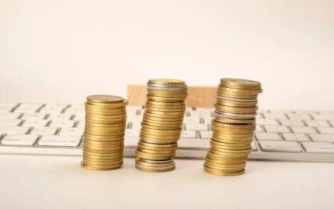 Golden Coins stack with keyboard in background Stock Photos