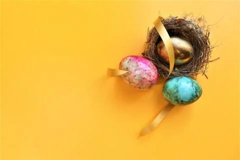 Golden colored easter eggs on yellow background Stock Photos