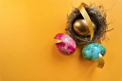 Golden colored easter eggs on yellow background Foto stock