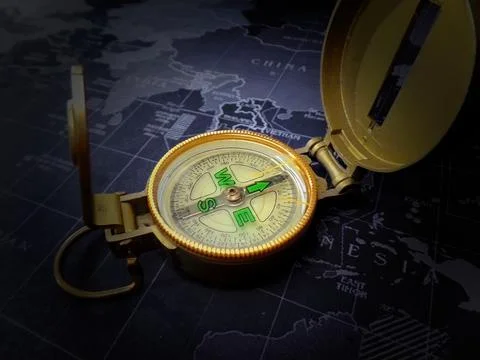 Golden compass on black map Stock Photos