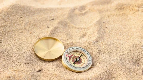 Golden compass falling on sand Stock Footage 286343222