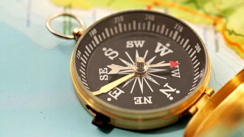 Golden compass lying on an abstract map Stock Footage 92409136
