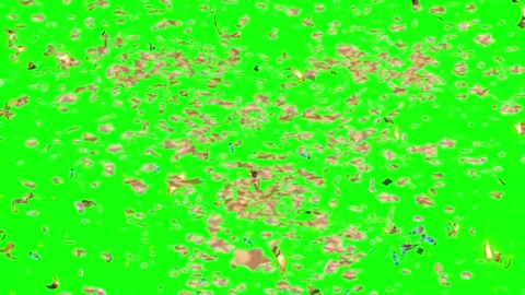 Golden confetti particles cascading downwards against a bright green screen 库存影片 344714589