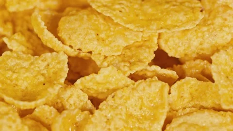Golden corn flakes for breakfast on rotating background. Food ingredient Stock Footage 143247762