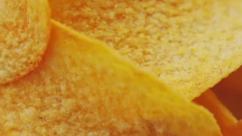 Golden Crispy Potato Chips Spinning in Bowl Overhead Macro Shot Stock Footage 314200102