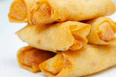 Golden, crispy spring rolls stacked neatly Stock Photos