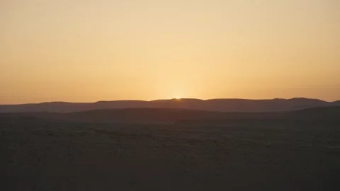 Golden desert sunset over distant silhouetted mountains Vídeos de archivo 316068823