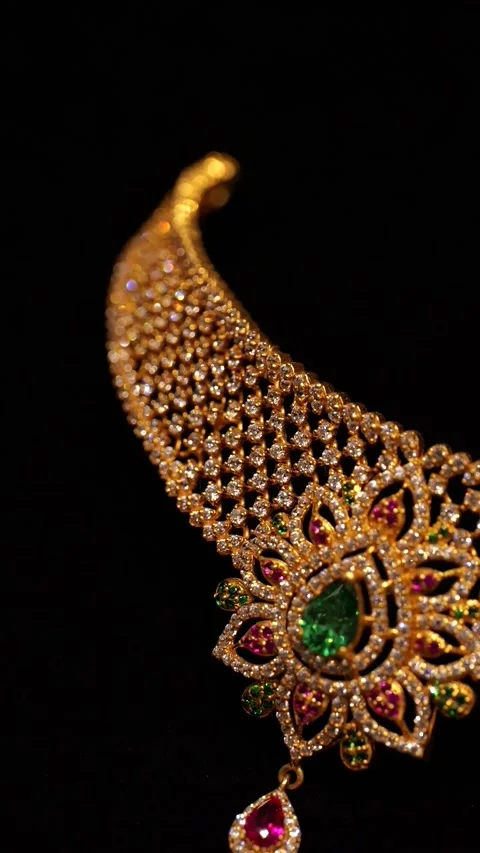 Golden diamond necklace featuring emerald and ruby gemstones rotating in slow mo Stock Footage 346248586