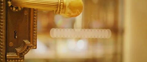 Golden door handle glows under soft light in Milan Cathedral interior museum Vidéo 321432906