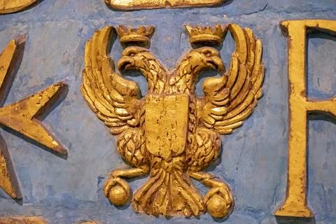 Golden double-headed eagle symbol on the wall in the interior Stock Photos