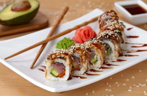 Golden dragon sushi roll with tuna, eel, cucumber, sesame seeds and tobiko Stock Photos