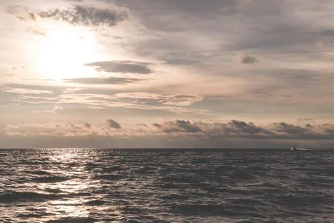 Golden dramatic ocean sky with sun reflected on waves 库存照片