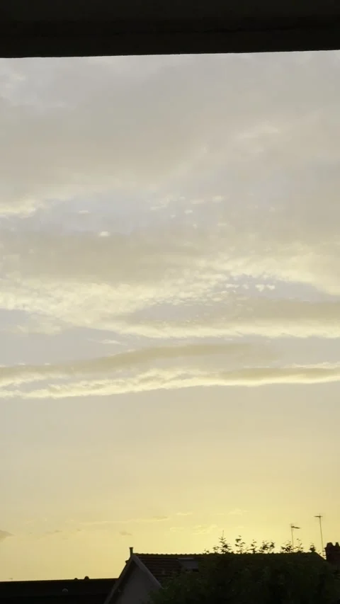 Golden Dusk Sky with Layered Clouds Above Rooftops Vertical Stock Footage 339555536