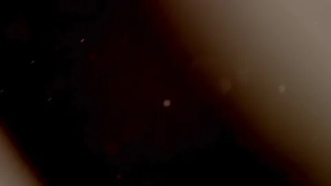 Golden dust particles float slowly across a dark background Stock Footage 329598210