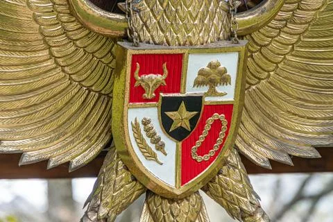 Golden eagles perched above a multi-colored, heraldic shield supported by c.. Stock Photos